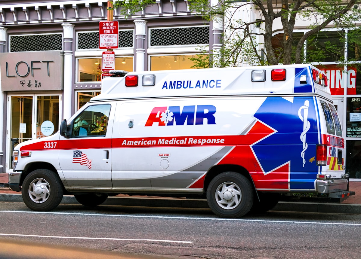 Ambulance parked at a hospital emergency entrance with lights visible
